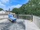 Outdoor deck with a blue chaise lounge, decorative rug and green leafy trees at 106 Twilight Overlook, Canton, GA 30114