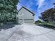 Side angle of a two-car garage, showing the driveway and partial lawn, set against a blue sky at 106 Twilight Overlook, Canton, GA 30114