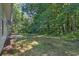 Lush backyard with dense trees providing privacy, adjacent to the home's exterior at 6541 Lazy Creek Ct, Lithonia, GA 30058