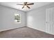 Bedroom with plush carpeting, ceiling fan, and natural light from window at 6541 Lazy Creek Ct, Lithonia, GA 30058