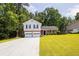 Traditional two-story home with a two-car garage, lush lawn, and mature trees at 6541 Lazy Creek Ct, Lithonia, GA 30058