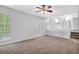 Spacious living room featuring natural light, plush carpet, access to a kitchen, and an outdoor patio at 6541 Lazy Creek Ct, Lithonia, GA 30058
