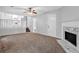 Cozy living room with a fireplace, neutral walls, staircase and plush brown carpeting at 6541 Lazy Creek Ct, Lithonia, GA 30058