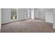 Bright living room features windows and neutral-toned carpet at 6541 Lazy Creek Ct, Lithonia, GA 30058