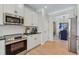 Well-equipped kitchen featuring stainless steel appliances, modern white cabinetry, and stylish countertops, adjacent to dining area at 99 Silver Leaf Trce, Douglasville, GA 30134