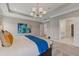 Light-filled main bedroom featuring a tray ceiling, modern lighting, and an en suite bathroom at 99 Silver Leaf Trce, Douglasville, GA 30134
