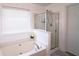 Bright bathroom featuring a soaking tub with jets and a glass-enclosed shower at 2428 Black Forest Dr, Conyers, GA 30012