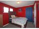 Bedroom with a wooden bed frame, red walls, and natural light at 2428 Black Forest Dr, Conyers, GA 30012