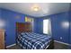 Blue bedroom with a wooden bed frame, blue walls, and natural light at 2428 Black Forest Dr, Conyers, GA 30012
