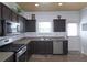 Functional kitchen with stainless steel appliances, dark cabinets, and tile flooring at 2428 Black Forest Dr, Conyers, GA 30012