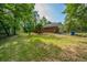 Lush backyard featuring a charming home, green lawn, mature trees, and a fenced area, perfect for outdoor enjoyment at 299 Fieldview Dr, Auburn, GA 30011