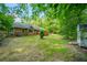 Expansive backyard view of a brick home, showcasing a spacious lawn, mature trees, and an outdoor shed at 299 Fieldview Dr, Auburn, GA 30011