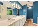 Bright blue bathroom featuring dual sinks, generous mirror and natural light at 299 Fieldview Dr, Auburn, GA 30011