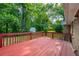 Spacious outdoor deck with red wood and railing, perfect for entertaining or relaxing in a serene, wooded setting at 299 Fieldview Dr, Auburn, GA 30011