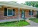 Inviting brick home featuring a charming front porch and well-manicured landscaping at 299 Fieldview Dr, Auburn, GA 30011
