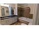 Well-lit bathroom with a soaking tub, tile surround and vanity with a black countertop at 3246 Able Ct, Marietta, GA 30062