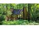 Exterior home view nestled among trees and lush foliage, with the front entrance and wooden steps visible at 3246 Able Ct, Marietta, GA 30062