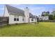 Large, grassy backyard featuring a patio, fence, and view of neighboring homes at 3971 Canebrake Ln, Douglasville, GA 30134