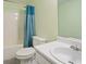 This bathroom has a shower/tub combination with a blue shower curtain, a toilet, and a sink vanity at 3971 Canebrake Ln, Douglasville, GA 30134
