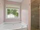 This bathroom features a soaking tub, separate shower, and a window overlooking the backyard at 3971 Canebrake Ln, Douglasville, GA 30134