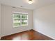 This bedroom has hardwood floors, white walls, and a window overlooking the front yard at 3971 Canebrake Ln, Douglasville, GA 30134