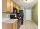 Efficient kitchen with oak cabinets, black appliances, and a white door, perfect for cooking at 3971 Canebrake Ln, Douglasville, GA 30134