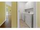 Bright laundry room with white washer, dryer, and upper cabinets at 3971 Canebrake Ln, Douglasville, GA 30134