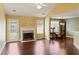 Sunlit living room with a fireplace and hardwood flooring, adjacent to a dining area and kitchen at 3971 Canebrake Ln, Douglasville, GA 30134