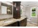 Bathroom featuring double sinks with granite countertops, dark wood cabinetry, and a large mirror at 4108 Berryhill Se Trce, Smyrna, GA 30082
