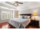 Comfortable main bedroom featuring a ceiling fan, tray ceiling, and natural light from the window at 4108 Berryhill Se Trce, Smyrna, GA 30082
