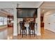 Stylish bar area with dark wood cabinets, stools, and open view into the kitchen at 1054 Morgan Garner Sw Dr, Lilburn, GA 30047