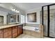 Bathroom featuring a jetted tub, a glass-enclosed shower, and a wooden vanity at 1054 Morgan Garner Sw Dr, Lilburn, GA 30047
