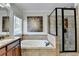 Bright bathroom with large tub, glass enclosed shower, and decorative artwork at 1054 Morgan Garner Sw Dr, Lilburn, GA 30047