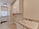 Bright laundry room with tile floor, storage cabinets and a utility sink at 1054 Morgan Garner Sw Dr, Lilburn, GA 30047