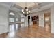 Spacious living room with hardwood floors, coffered ceilings, chandelier, and view into the kitchen at 1054 Morgan Garner Sw Dr, Lilburn, GA 30047