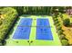 Aerial view of well-maintained community tennis courts with pristine green and blue surfaces and lighting at 1054 Morgan Garner Sw Dr, Lilburn, GA 30047