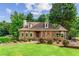 Charming home featuring a stone facade, arched windows, and a well-manicured front lawn at 150 Wilbanks St, Buford, GA 30518