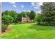 Expansive front yard featuring a well-maintained lawn, mature trees, and beautiful landscaping at 150 Wilbanks St, Buford, GA 30518
