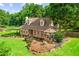 Charming stone home with lush lawn, garden beds, and mature trees, creating a welcoming exterior at 150 Wilbanks St, Buford, GA 30518