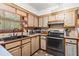 Close-up of the kitchen showcasing sleek black appliances, neutral cabinetry, and tiled flooring at 150 Wilbanks St, Buford, GA 30518