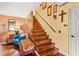 Charming staircase with hardwood treads, a wooden banister, and a cozy seating area at 150 Wilbanks St, Buford, GA 30518