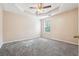 Bright bedroom features neutral walls, ceiling fan, trey ceiling, and gray carpet at 1592 Smithson Ct, Lithonia, GA 30058