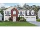 Charming two-story home featuring a red brick facade, well-manicured lawn, and attached two-car garage at 1592 Smithson Ct, Lithonia, GA 30058