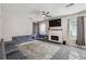 Bright living room with carpeting features a fireplace, custom sofa, ceiling fan and natural light at 1592 Smithson Ct, Lithonia, GA 30058