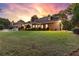 Expansive backyard featuring lush green grass, mature trees, and a well-maintained brick home with a patio at 248 Montrose Dr, Mcdonough, GA 30253