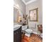 Stylish half bathroom with a modern vanity, decorative mirror, and hardwood floors at 248 Montrose Dr, Mcdonough, GA 30253