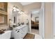Bathroom with double sinks, framed artwork, animal print rug, and doorway to bedroom at 248 Montrose Dr, Mcdonough, GA 30253