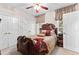 Comfortable bedroom with decorative bedding, fan, and doorway to an adjacent room at 248 Montrose Dr, Mcdonough, GA 30253