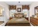 Relaxing bedroom with patterned bedding, framed artwork, ceiling fan, and side tables at 248 Montrose Dr, Mcdonough, GA 30253
