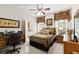 Cozy bedroom with patterned bedding, framed artwork, ceiling fan, and adjacent bathroom at 248 Montrose Dr, Mcdonough, GA 30253